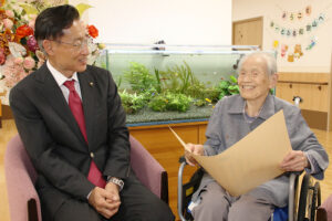 尾﨑市長㊧と笑顔で話す前田さん