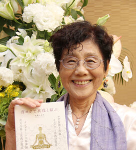 新書を手に笑顔の松尾さんのアイキャッチ画像