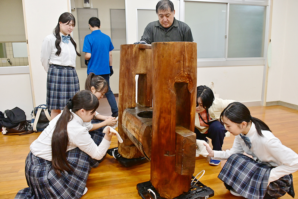 借り受けた「立木式搾油機」に触れる生徒