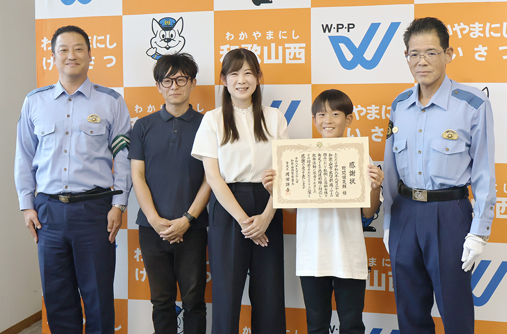 岡田署長㊨から感謝状を受け取った野間田さん(左から4人目)