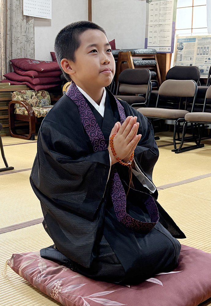 仏前で合掌する魁仁さん