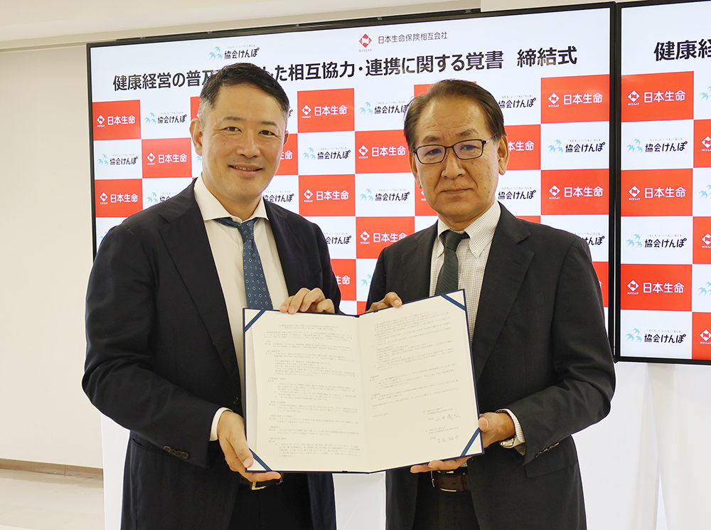 締結書を交わした山田支部長㊨と吉谷支社長