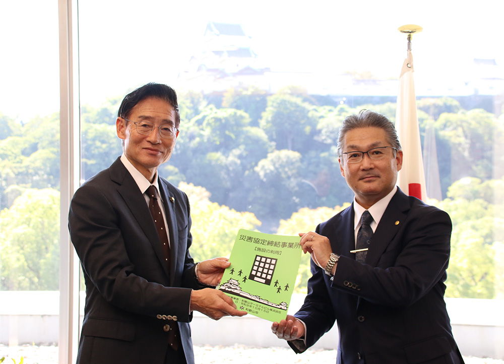武田社長㊨に認定プレートを手渡す尾﨑市長